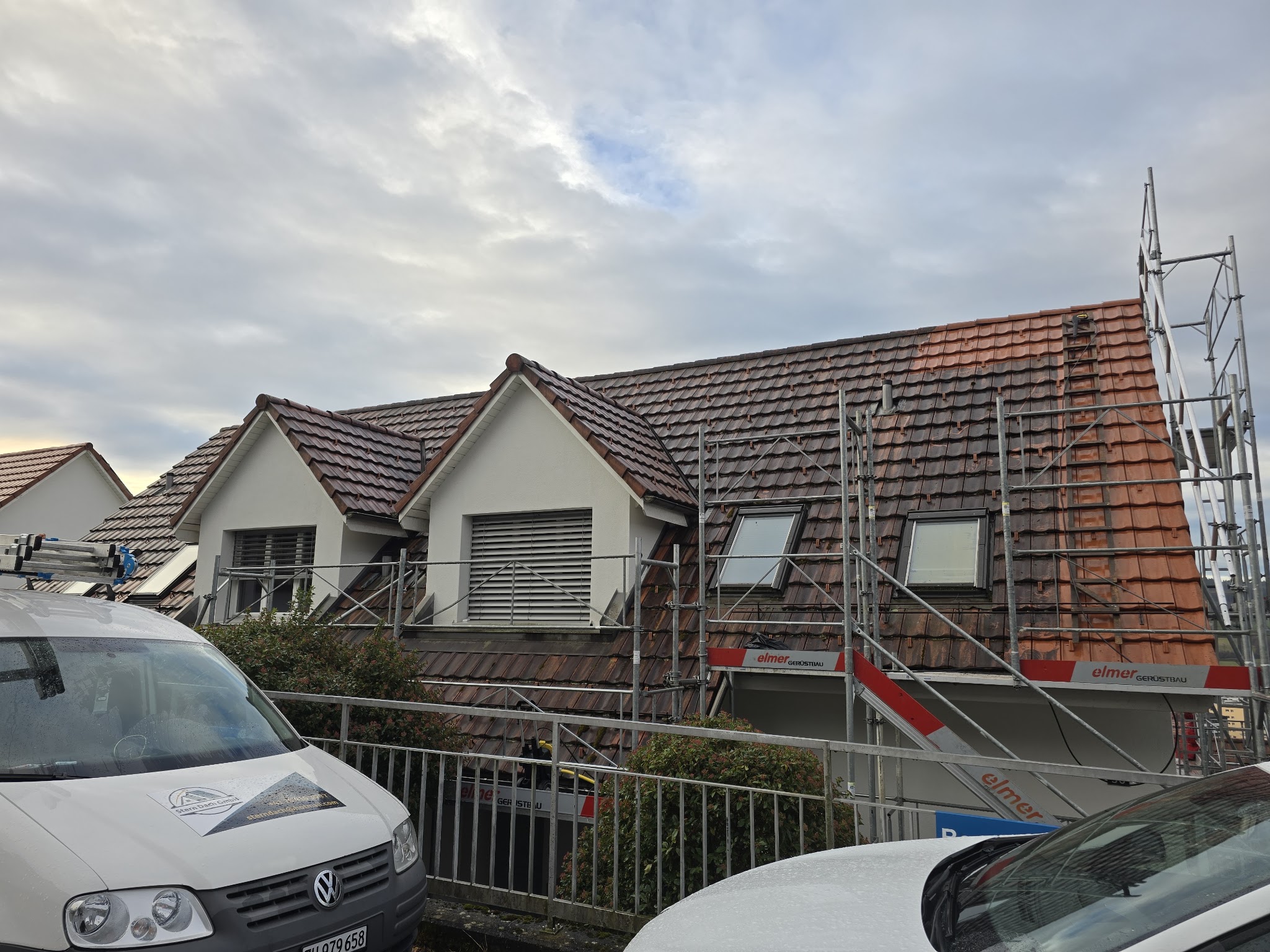 Stern Dach GmbH bei der Arbeit an einem Steildach mit Firmenfahrzeug